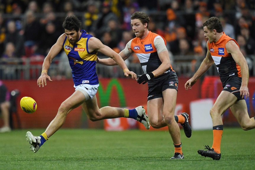 Josh Kennedy of the Eagles (left) runs after a loose ball against GWS.