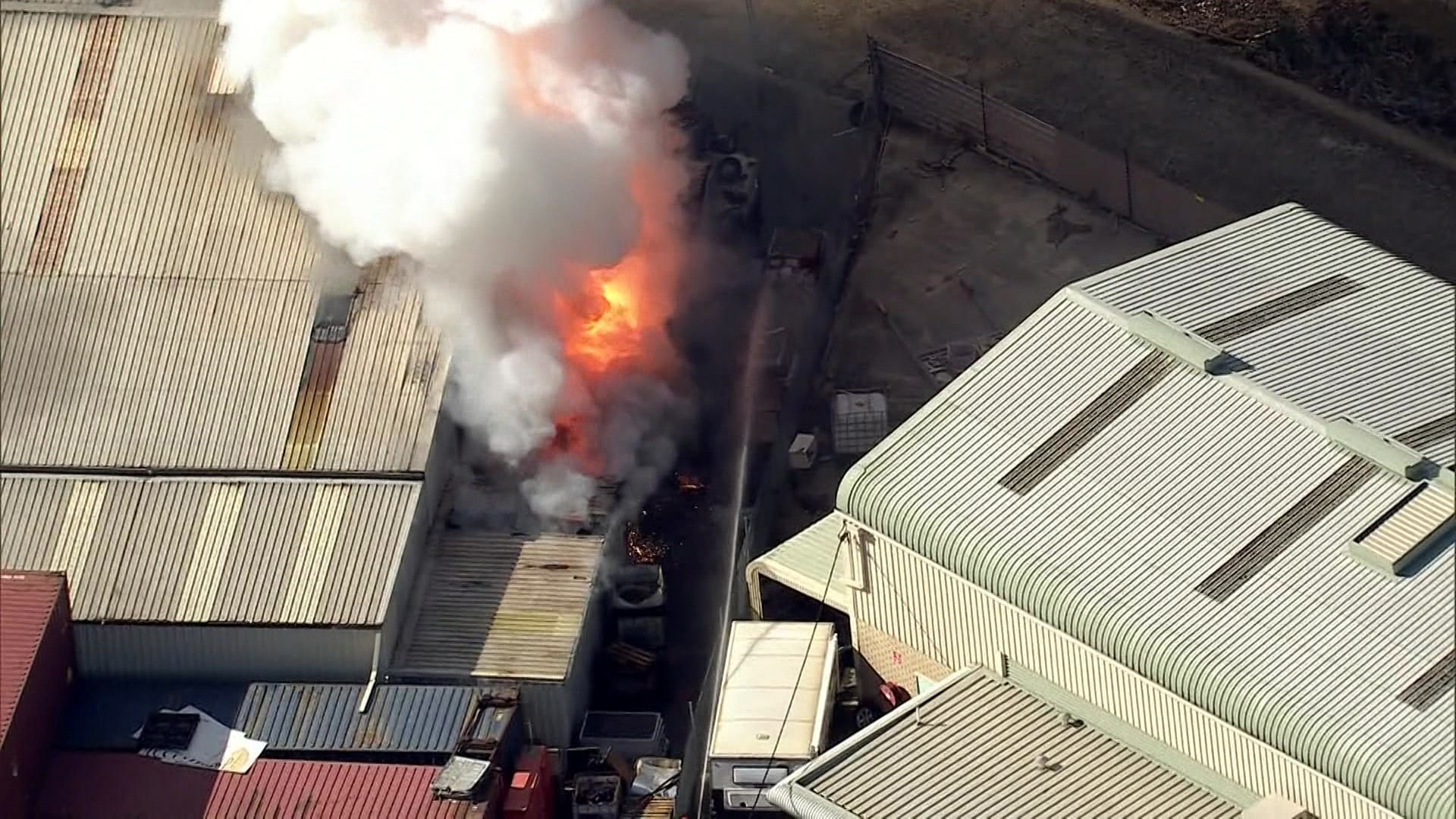 औद्योगिक क्षेत्र की एक इमारत से आग की लपटें निकलती देखी जा सकती हैं। 