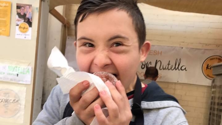 A boy eats a donut.