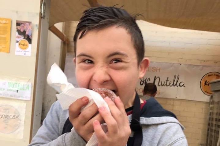 A boy eats a donut.