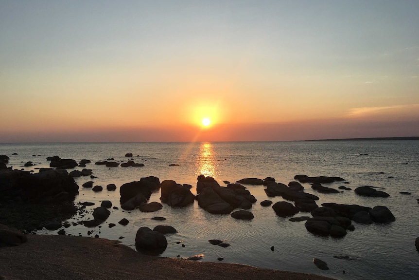 The sun sets across the beach at Groote Eylandt.