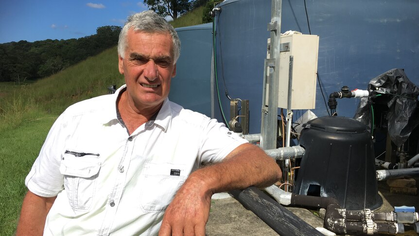 Larry Karlos next to his water extraction pump and tanks