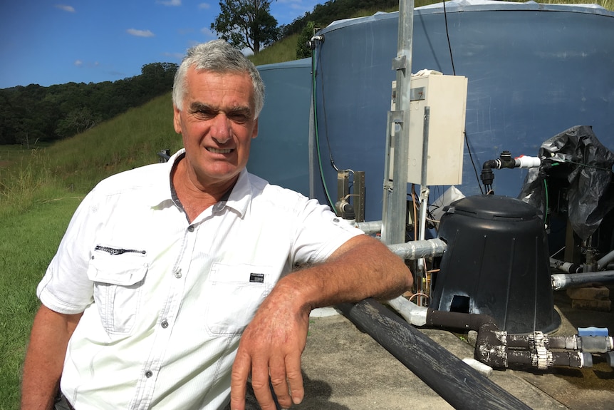 Larry Karlos next to his water extraction pump and tanks