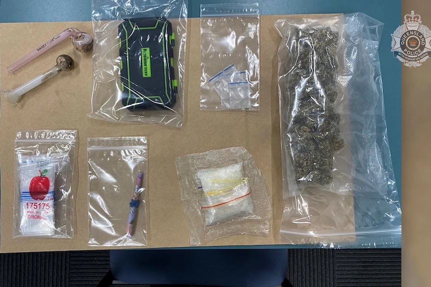 Evidence including drugs and other evidence in plastic bags on a table.