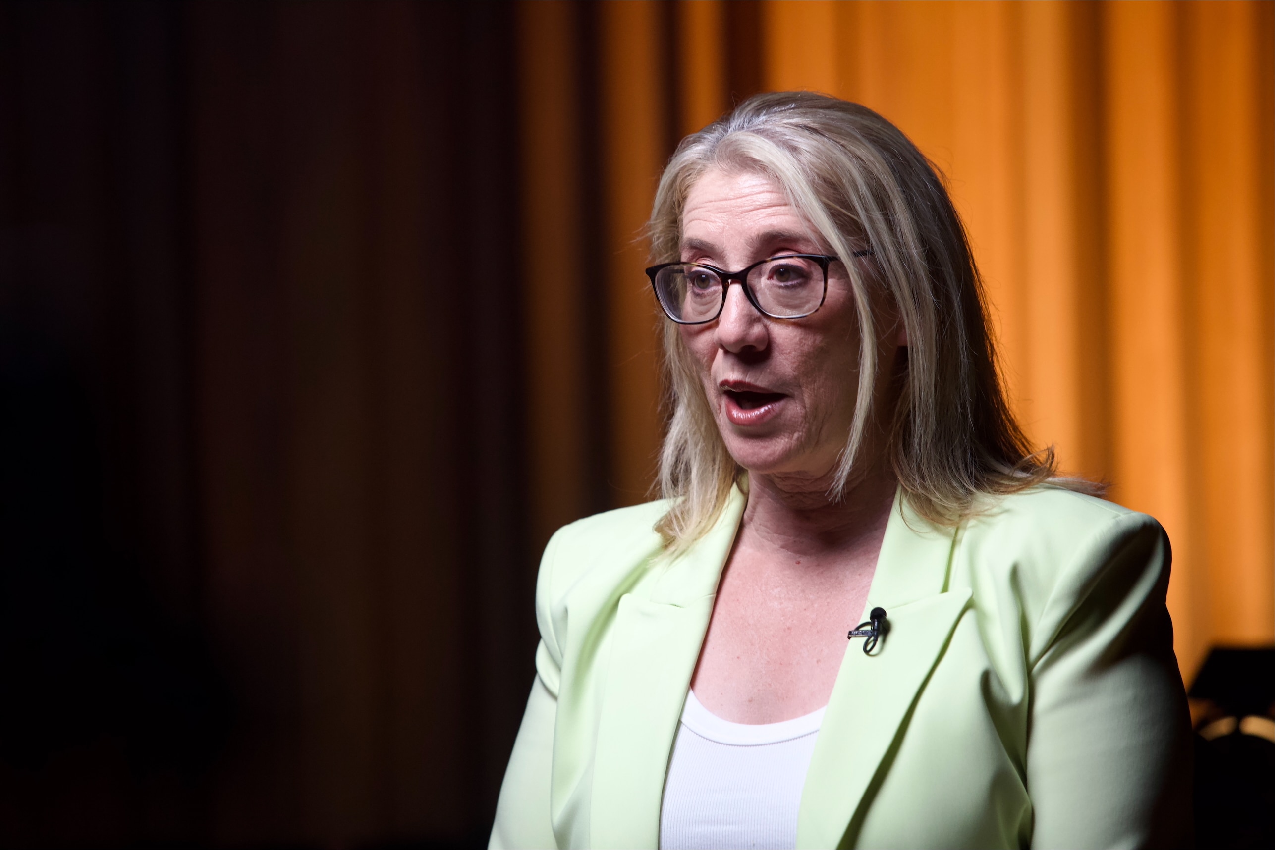 A close-up head and shoulders shot of WA Treasurer Rita Saffioti wearing a green jacket and white top during an interview.