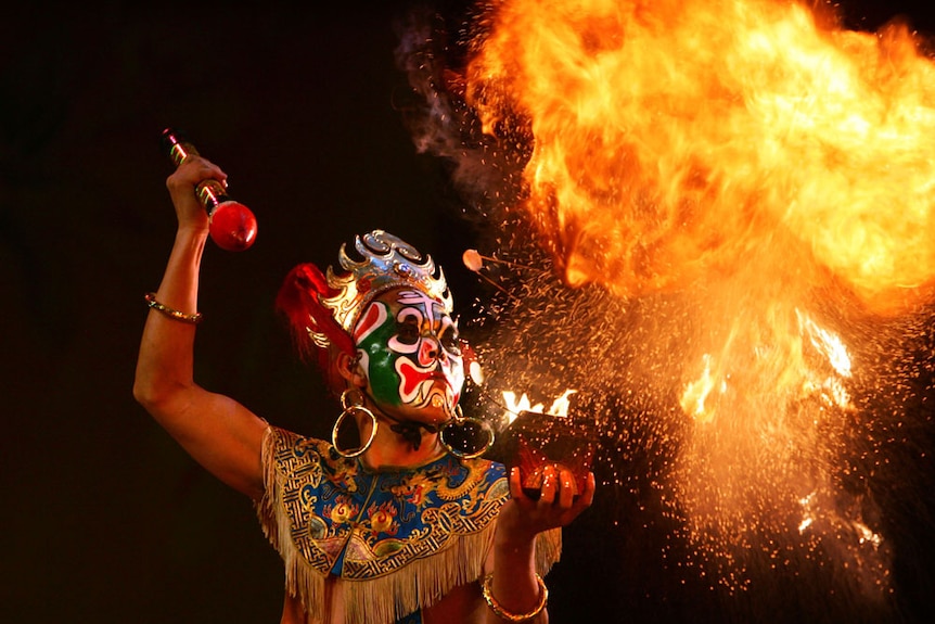 A Sichuan Opera actor performs fire breathing during a show of traditional operas.