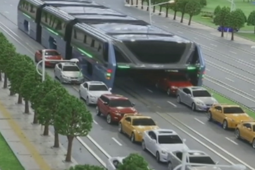 A model of a bus built to sit across two lanes of traffic with cars passing underneath.