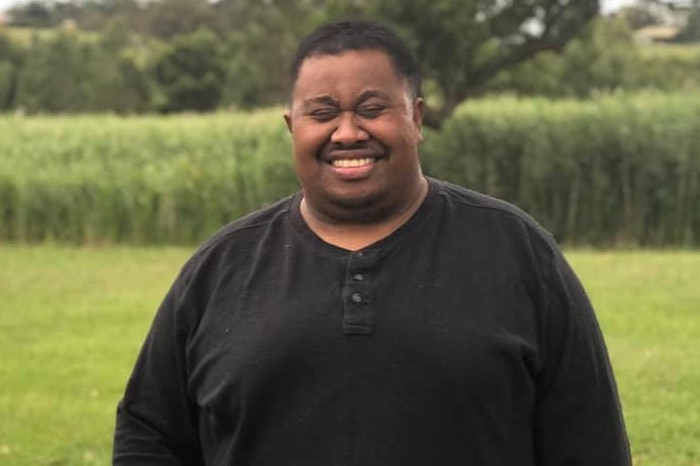 Max Lasea Tavai smiles in a park.