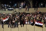 Protesters celebrate in the courtyard after breaking into Baghdad's Green Zone.