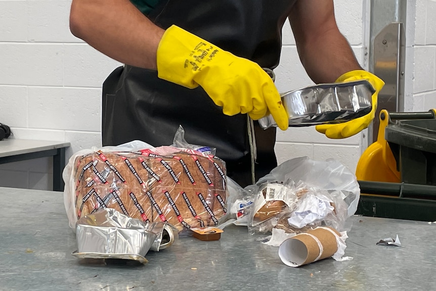 An inmate sorts through rubbish as part of a recycling program at the prison