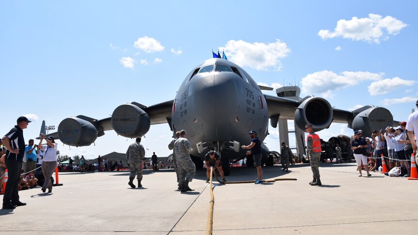 Grant Edwards pulls aircraft surrounded by crowd.