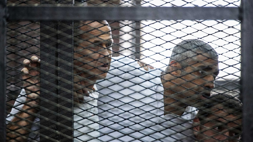 Peter Greste, Mohamed Fahmy and Baher Mohamed listen to their verdict.
