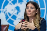 Maria van Kerkhove speaks during a news conference in front of a World Health Organization sign.