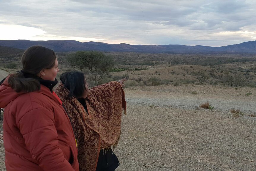 younger Aboriginal woman next to Aboriginal elder who is pointing and looking to the South Australian landscape in the distance