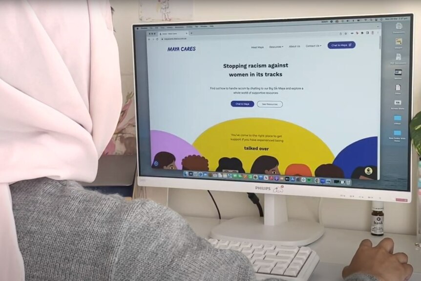 A woman wearing a headscarf uses a the Maya Cares chatbot on a computer.