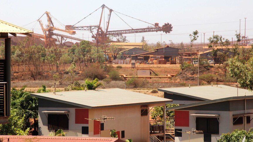 Huge mining machinery with houses in the foreground.
