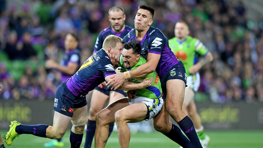 Jordan Rapana wrapped up by the two Melbourne Storm tacklers.
