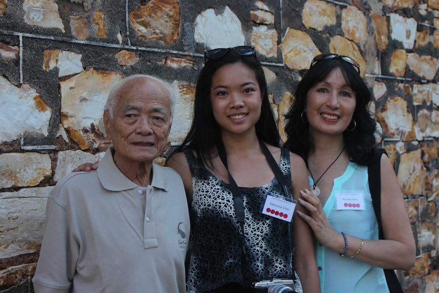 Hamilton Chan, Stephanie Chan and Rosalie Hiah pictured next to an exterior wall of the Stone House.