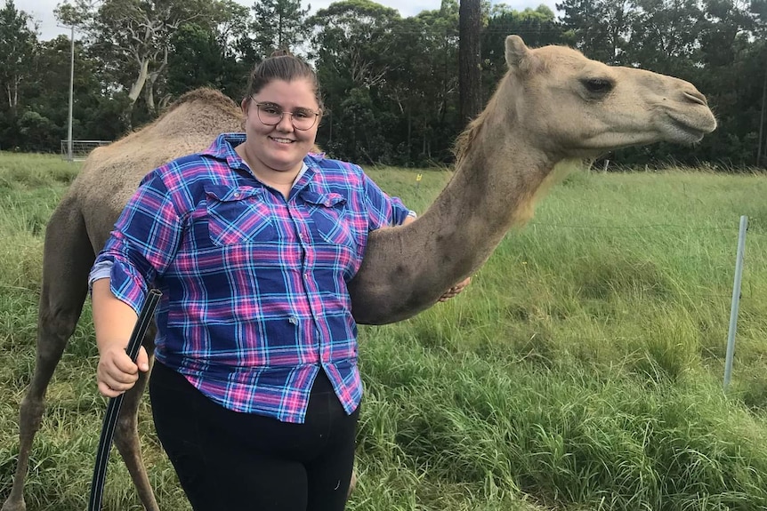 Anna-Rose before surgery next to a camel. 