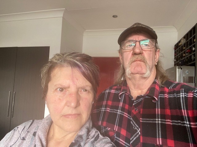 A woman and man with angry facial expressions in their kitchen. 