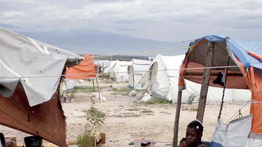 Haitian earthquake survivor Premio Samdi (left) organises material for strengthening his tent in preparation for Tropical Storm Tomas.