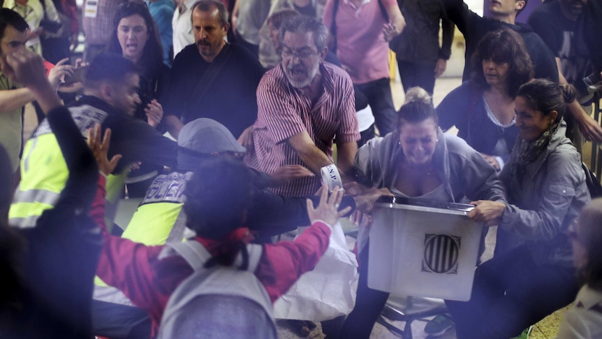 Spanish National Police officers in plain clothes try to snatch a ballot box.