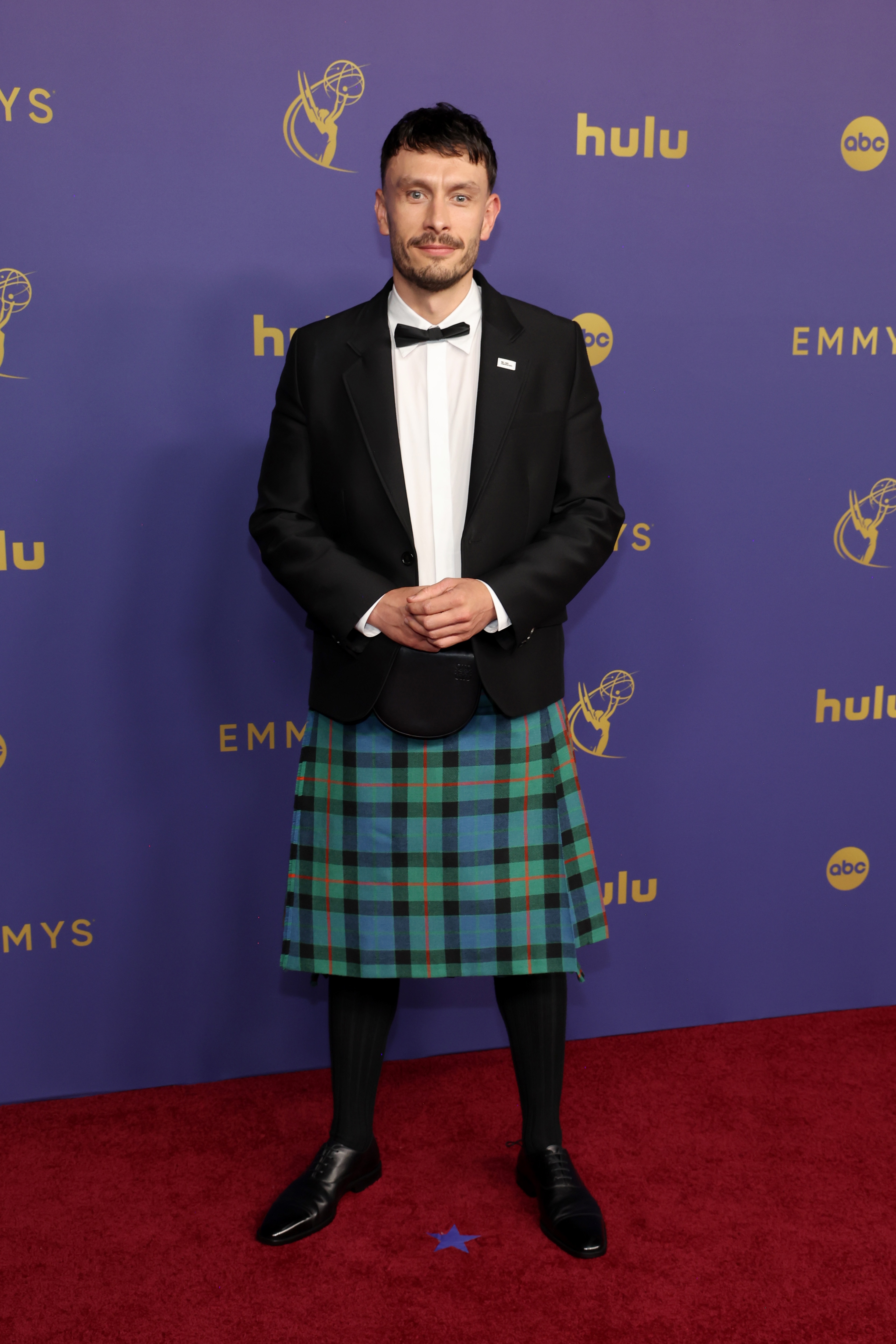 Richard Gadd wearing a black suit, black bowtie, white button-up shirt and a green and blue kilt