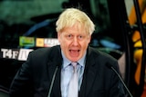 Boris Johnson behind a mic stand giving a speech