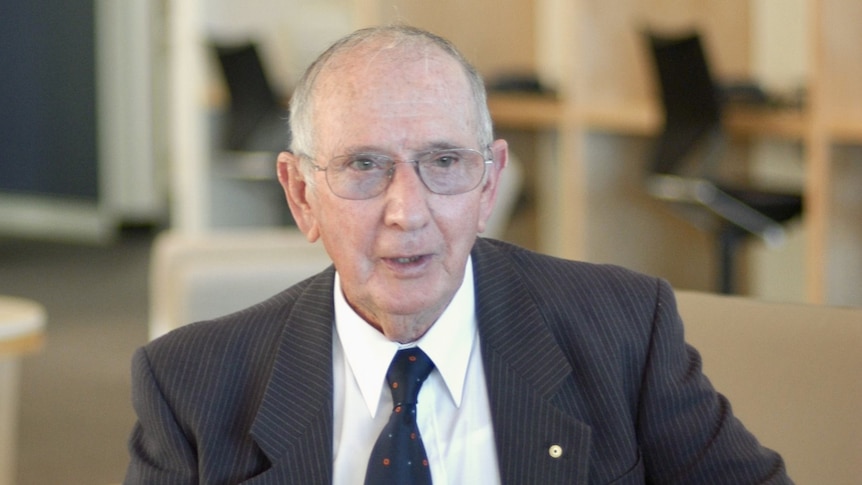 An elderly man wearing a suit