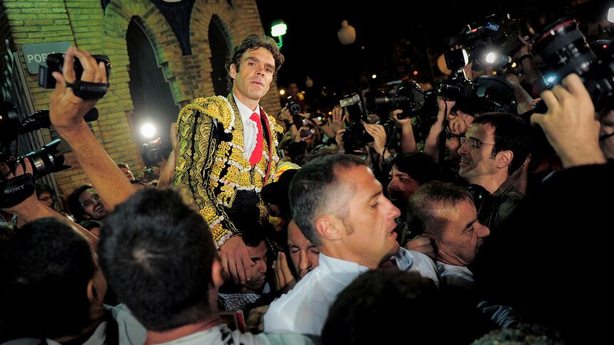Spanish matador Jose Tomas celebrates after being awarded two ears and a tail at the Plaza Monumental bullring in Barcelona