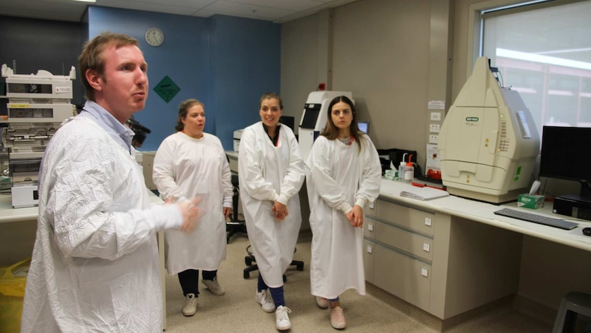 Three young women and a lab scientist are in the wet lab.