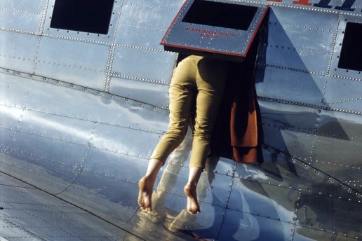 Woman's legs outside of window of small aeroplane