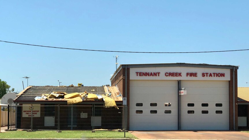 A building with sign saying Tennant Creek Fire Station with with insulation falling off the roof.