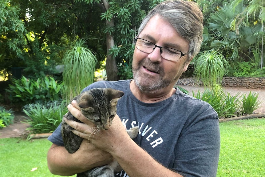 Man in the garden holding a kitten