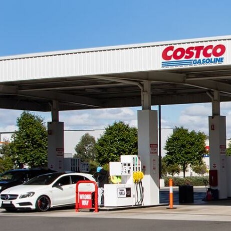 costco petrol station from afar with white cars at the bowser under white cover with red and blue signage