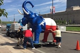 Organisers handle a giant elephant statue that's been painted a patriotic red, white and blue.