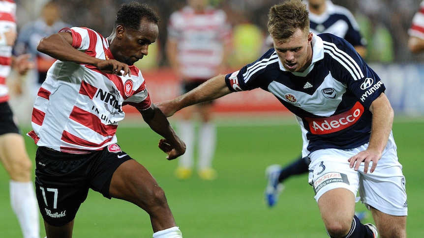 Daniel Mullen (R) takes the ball forward for Melbourne Victory