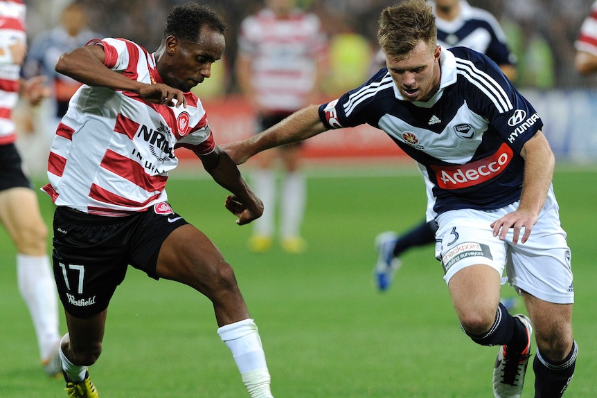 Daniel Mullen (R) takes the ball forward for Melbourne Victory