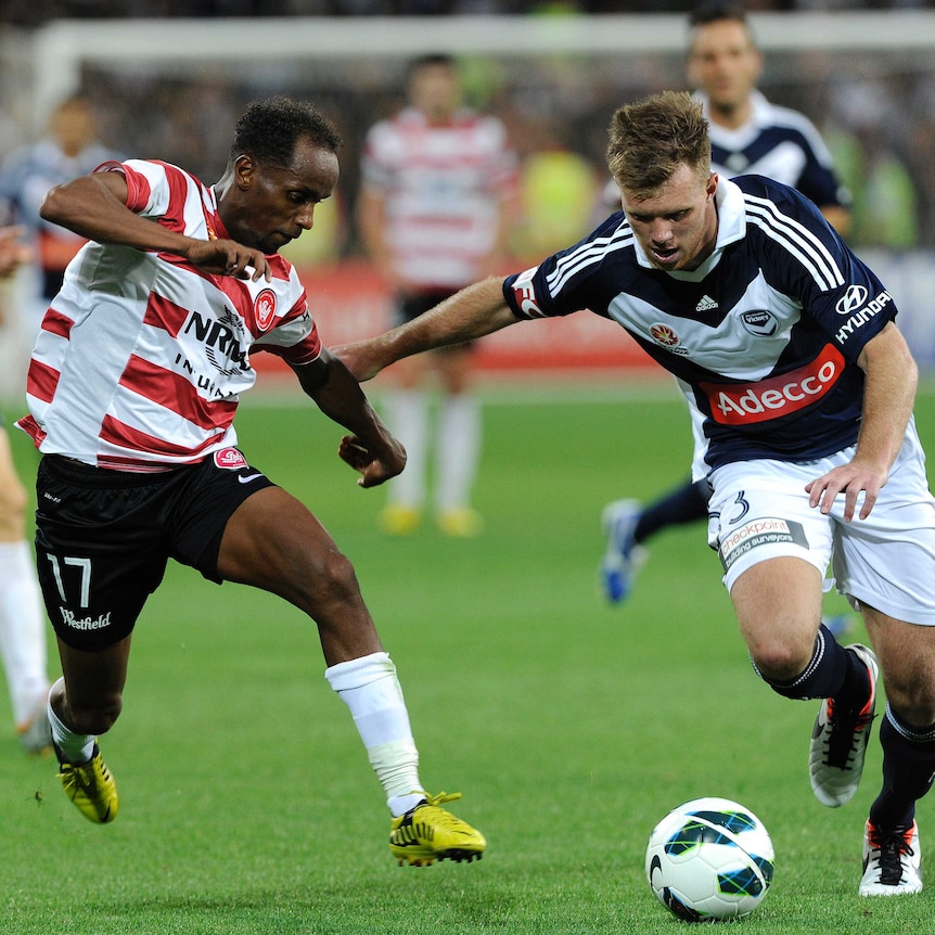 Melbourne Victory's Daniel Mullen (R) goes against the Wanderers' Youssouf Hersi in round 21, 2013.