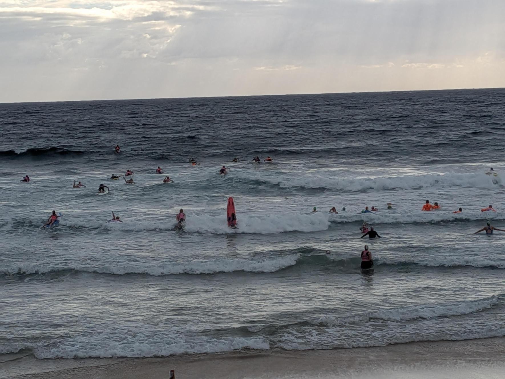 Dezenas de surfistas e nadadores na praia