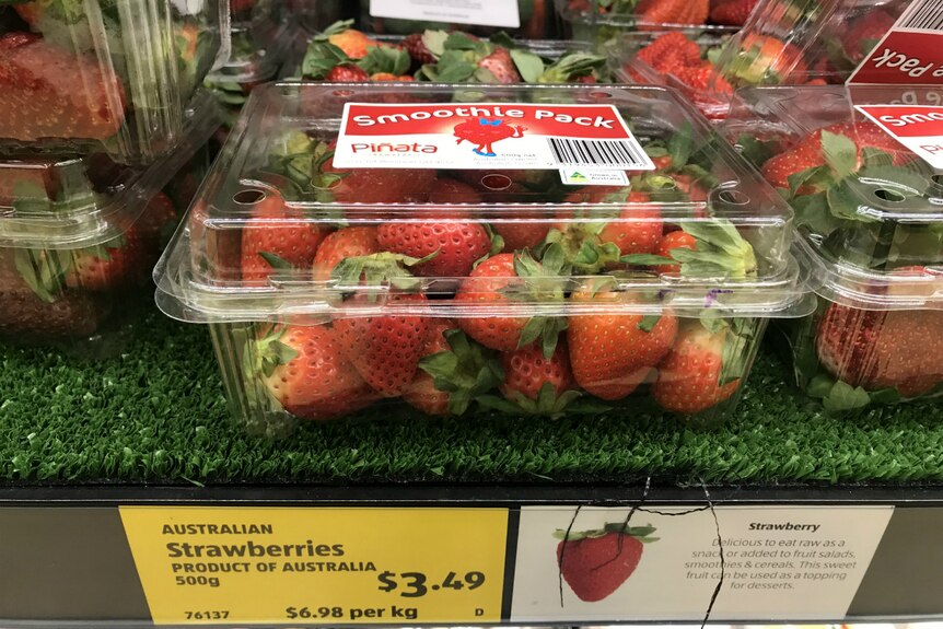 A big punnet of strawberries labelled 'Smoothie pack' on the supermarket shelf.