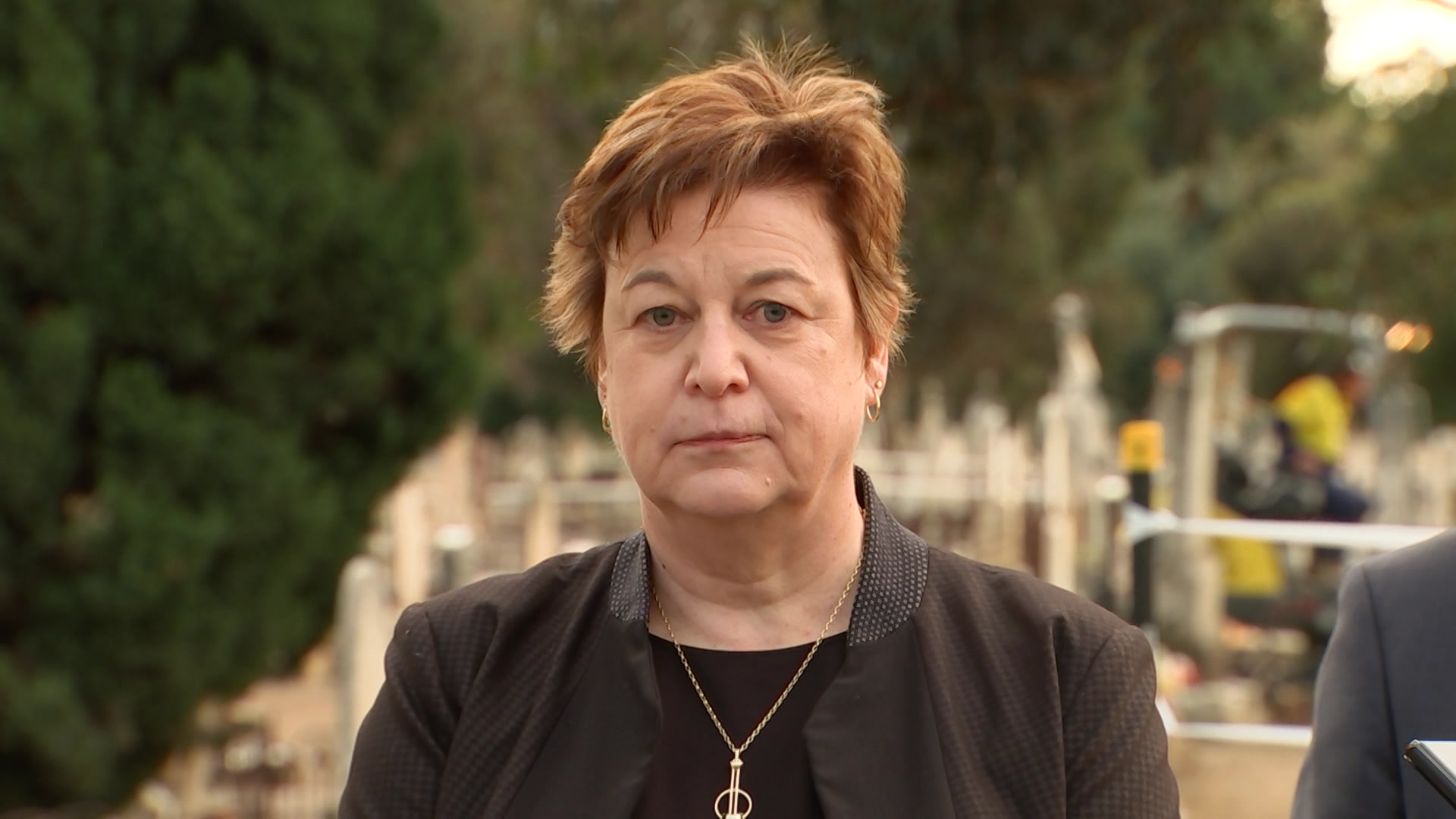 A portrait photo of a woman in a cemetery.