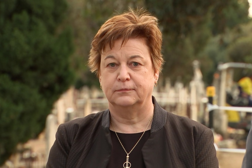 A portrait photo of a woman in a cemetery.