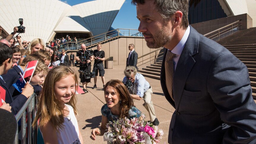 Denmark's Crown Prince Frederik and Crown Princess Mary greet the crowd in front of the Sydney Opera House in Sydney on 24 October 2013