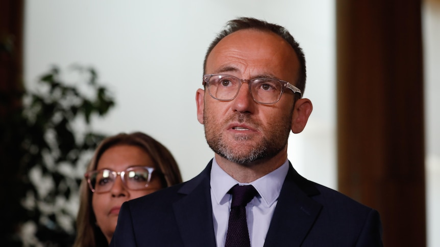Adam Bandt wearing a suit and tie with the background out of focus