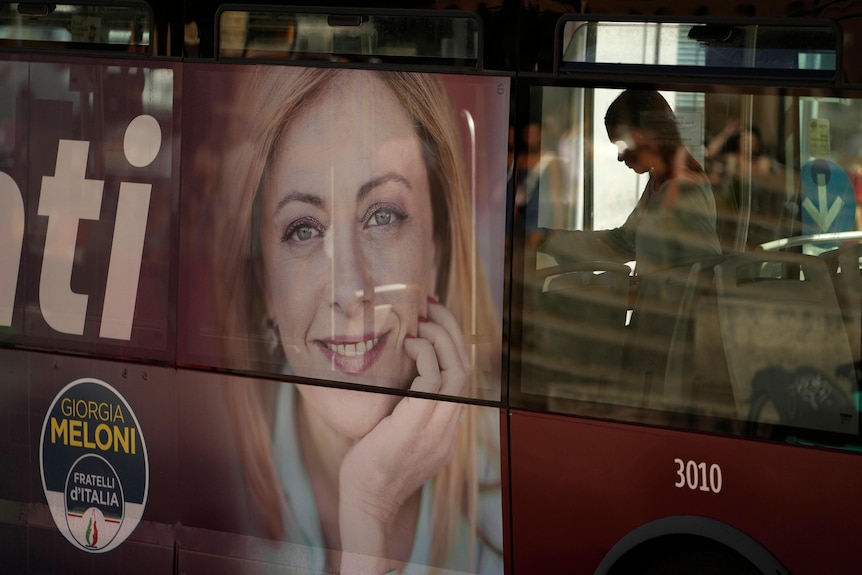 A poster of a woman with blonde hair smiling on a bus with a woman standing onboard.