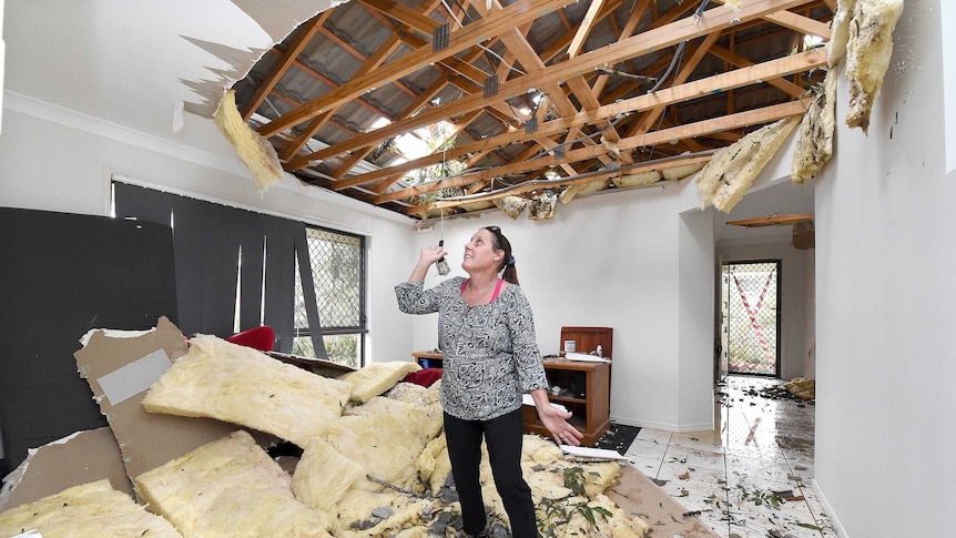 Lana Band looks at where the ceiling was in her home in Fernvale, after a severe storm damaged her house.