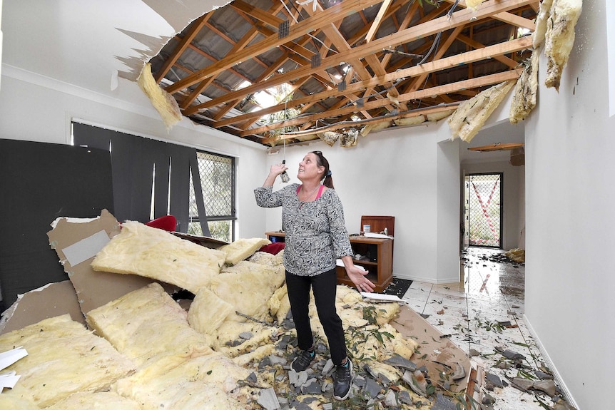 Lana Band looks at where the ceiling was in her home in Fernvale, after a severe storm damaged her house.