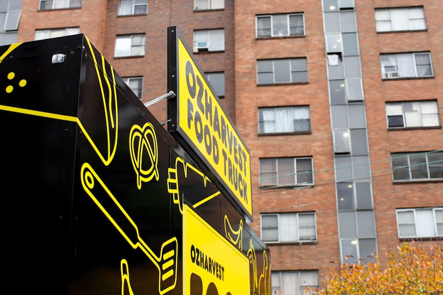 OzHarvest food truck sign in front of an apartment building