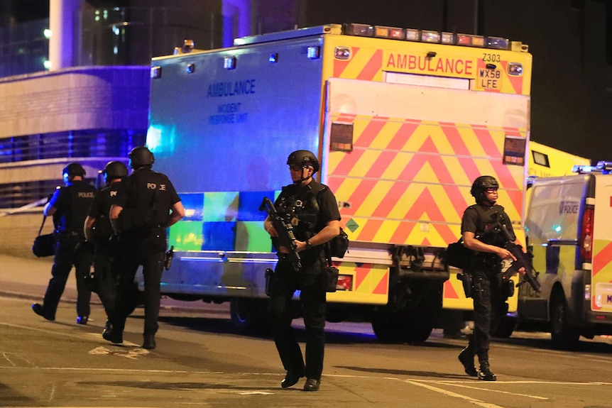 Armed police surround an ambulance outside Manchester Arena.